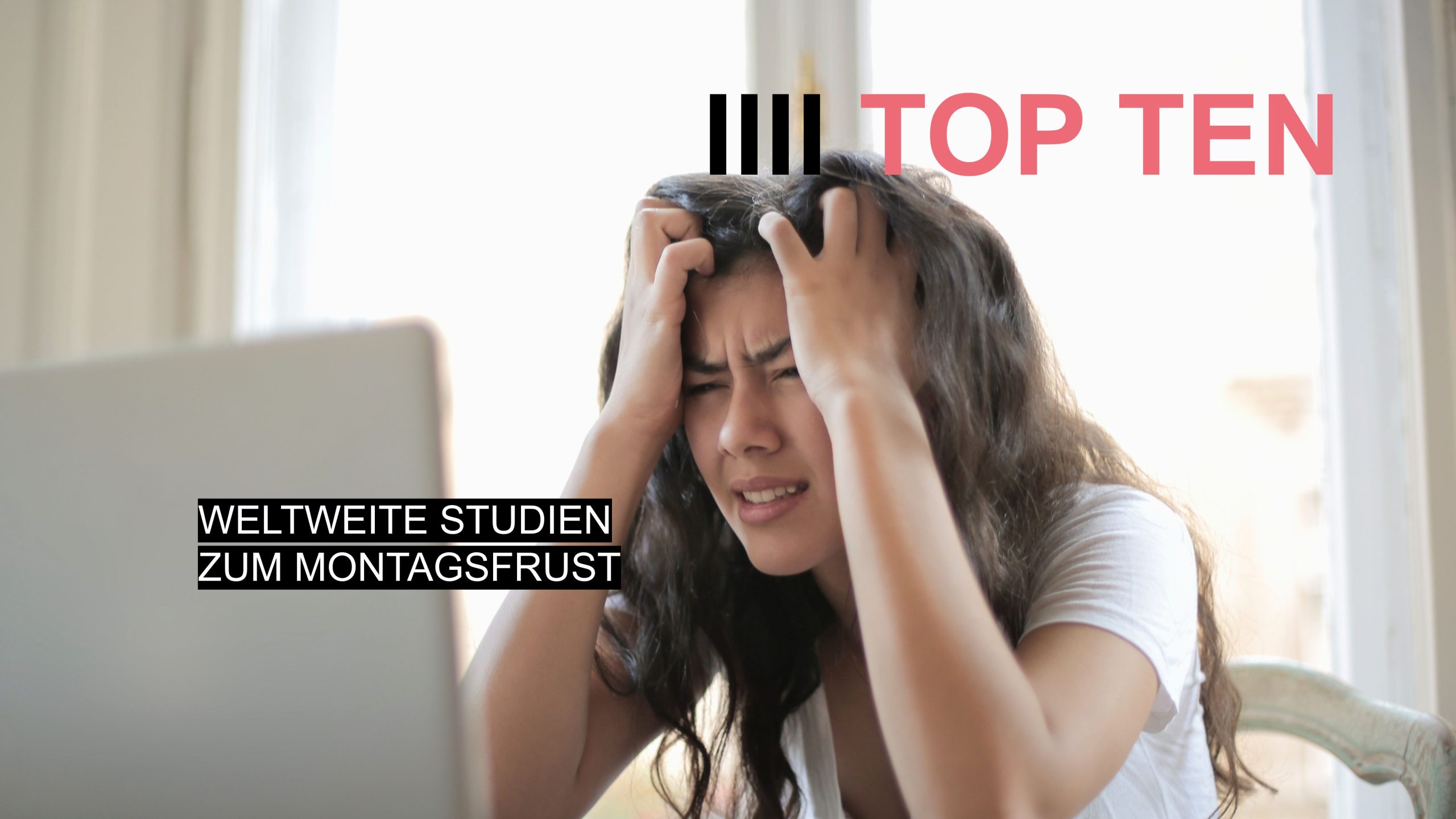 Junge Frau im Büro vor dem Laptop, die sich frustriert die Haare rauft – Symbol für Montagsfrust und Montagsdepression