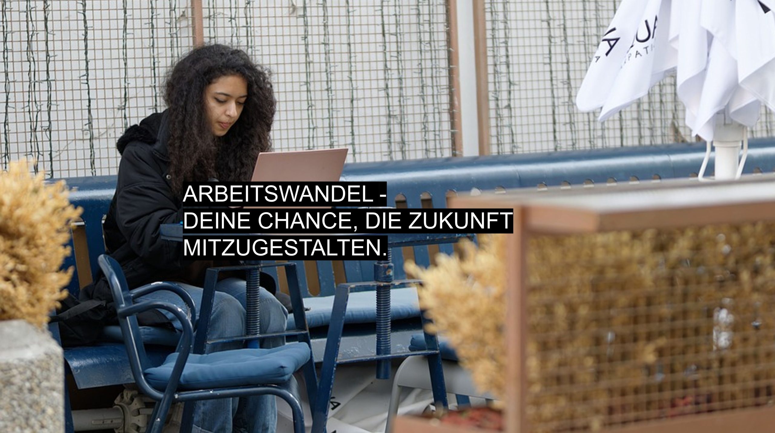 Frau arbeitet draußen im Café mit Laptop – Symbol für Arbeitswandel, mobiles Arbeiten und die Zukunft der Arbeit