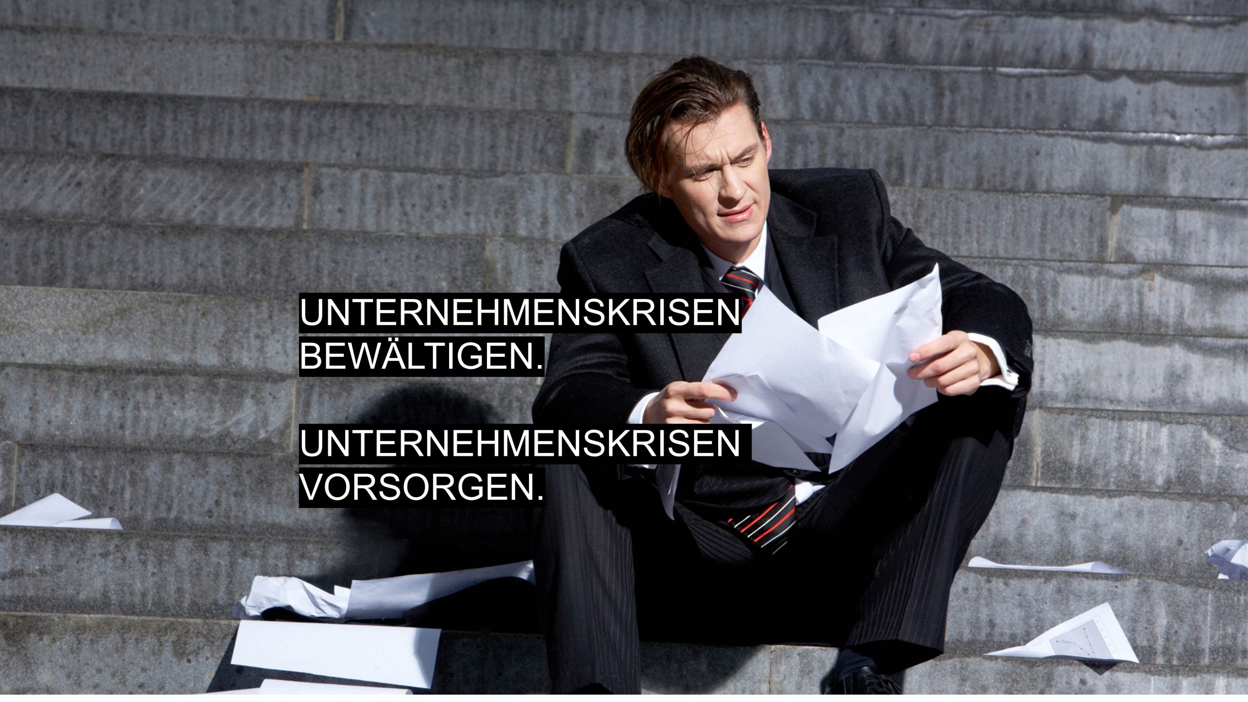 Gestresster Geschäftsmann sitzt auf einer Treppe, während Papiere umherfliegen – Symbol für Unternehmenskrisen und deren Bewältigung.