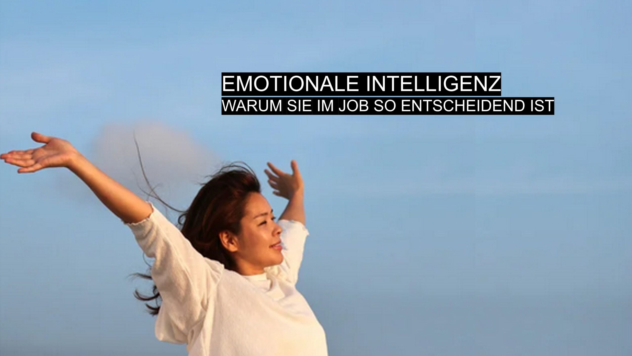 Frau mit offenen Armen vor blauem Himmel als Symbol für emotionale Intelligenz und innere Stärke im Beruf.