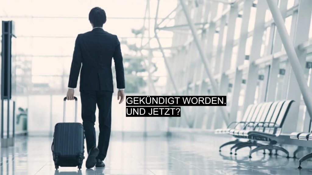 Geschäftsmann mit Koffer verlässt ein Gebäude. Symbolbild für Kündigung und beruflichen Neuanfang.
