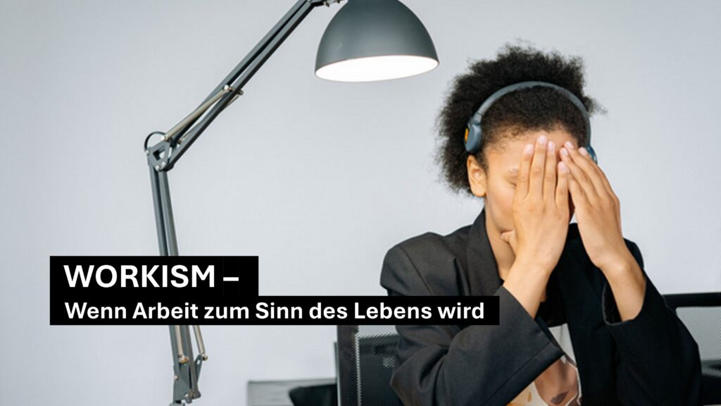 Workism im Job: erschöpfte Person im Büro verdeckt das Gesicht – Symbol für Überidentifikation mit Arbeit und Stress