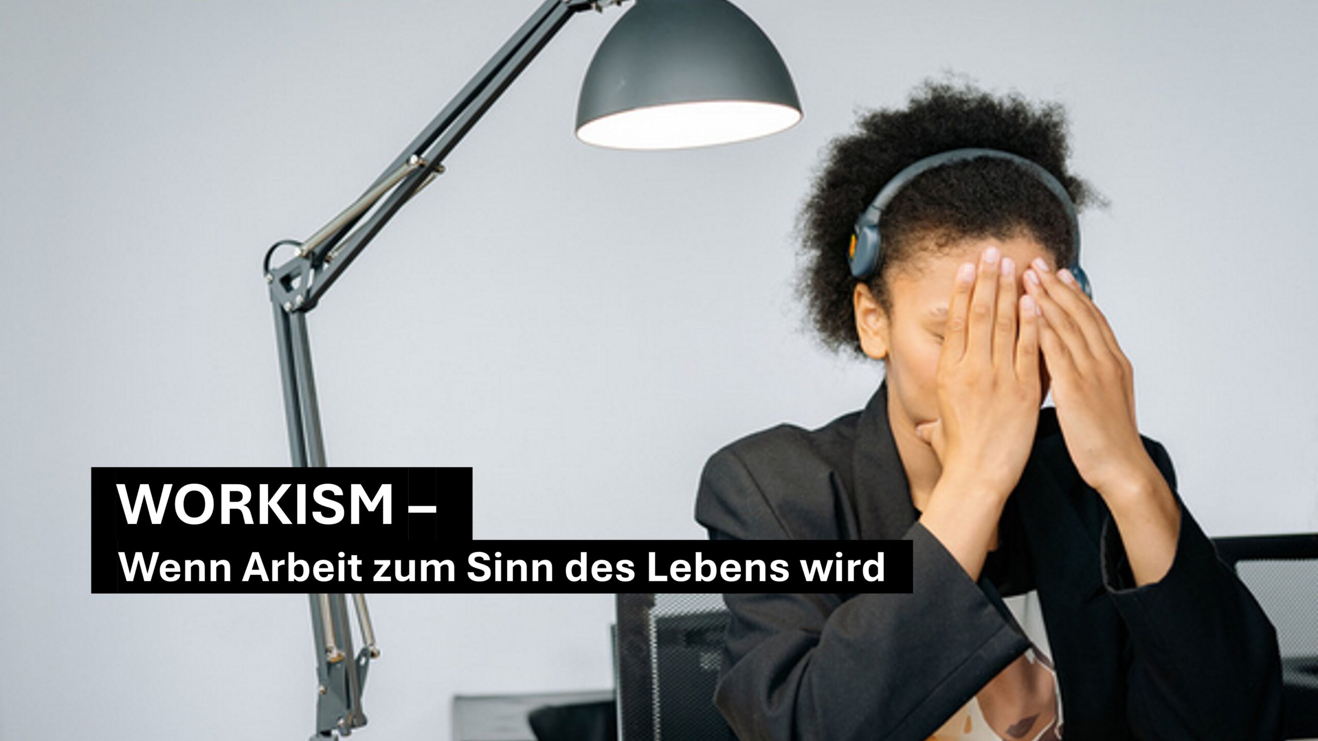 Workism im Job: erschöpfte Person im Büro verdeckt das Gesicht – Symbol für Überidentifikation mit Arbeit und Stress